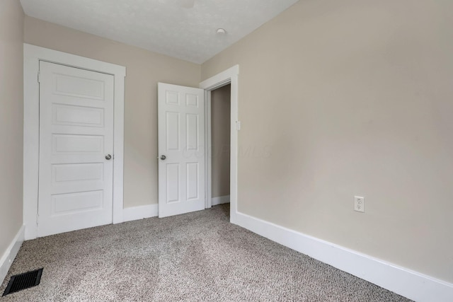 unfurnished bedroom featuring carpet, visible vents, and baseboards