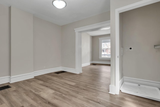 spare room with visible vents, baseboards, and wood finished floors