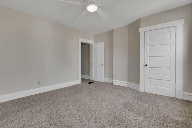 empty room featuring carpet flooring, ceiling fan, visible vents, and baseboards