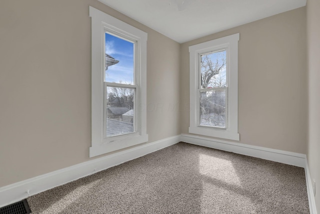 empty room with visible vents, baseboards, and a wealth of natural light