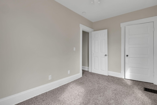 unfurnished bedroom with carpet, visible vents, and baseboards