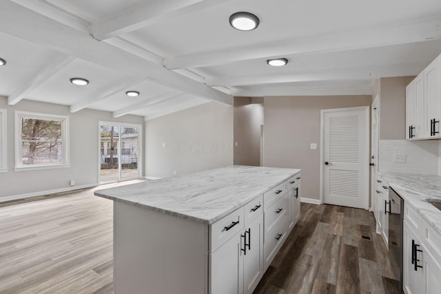 kitchen with lofted ceiling with beams, tasteful backsplash, a kitchen island, and wood finished floors