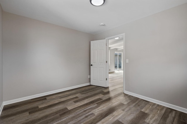 empty room with baseboards and wood finished floors