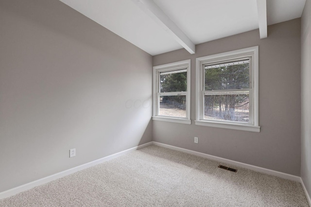 empty room with carpet, visible vents, lofted ceiling with beams, and baseboards