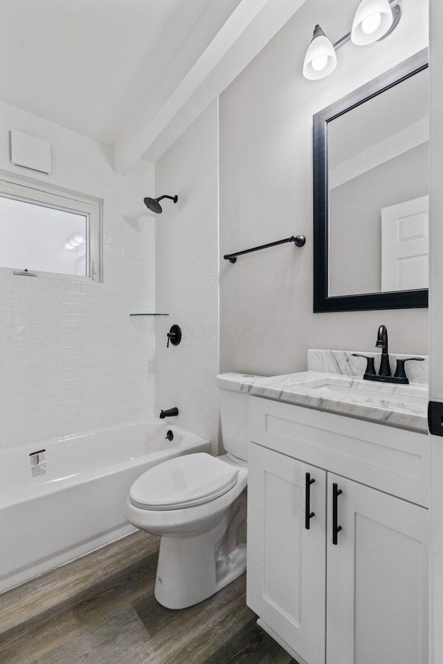 full bath with toilet, washtub / shower combination, wood finished floors, and vanity