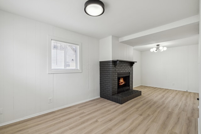 unfurnished living room with light wood-style flooring, a fireplace, and baseboards