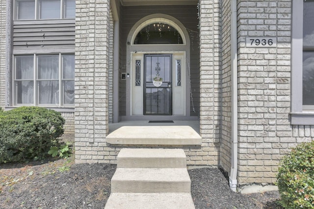 view of exterior entry featuring brick siding