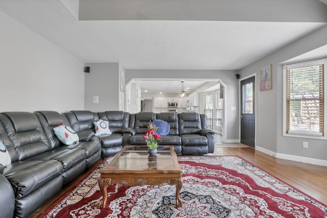 living area with baseboards and wood finished floors