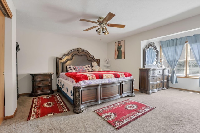 carpeted bedroom with baseboards and a ceiling fan