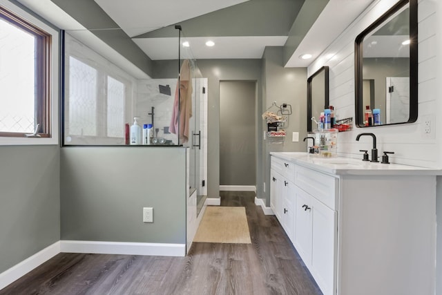 full bathroom with baseboards, wood finished floors, a sink, and a shower stall