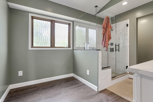 full bath with a stall shower, baseboards, wood finished floors, and recessed lighting