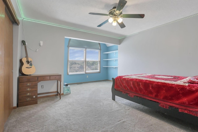 carpeted bedroom with ceiling fan and a textured ceiling