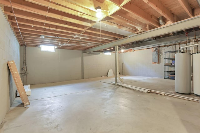 basement featuring electric panel and water heater