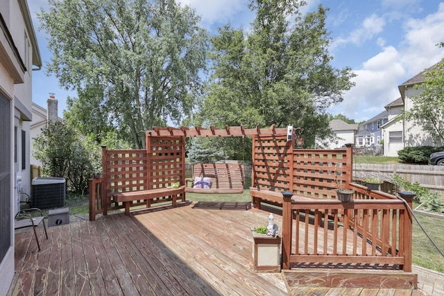 wooden terrace featuring fence and cooling unit