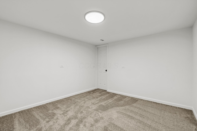 carpeted spare room featuring baseboards