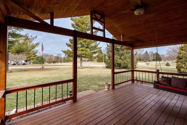 deck with a ceiling fan and a yard