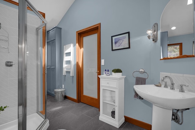 bathroom with a shower stall and baseboards