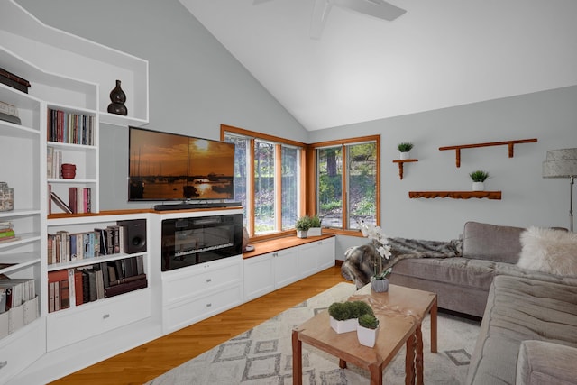 living area with lofted ceiling, ceiling fan, and light wood-style floors