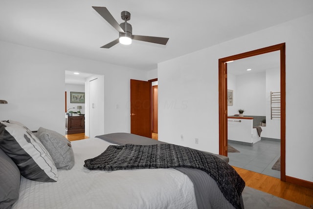 bedroom featuring ceiling fan, wood finished floors, and ensuite bathroom