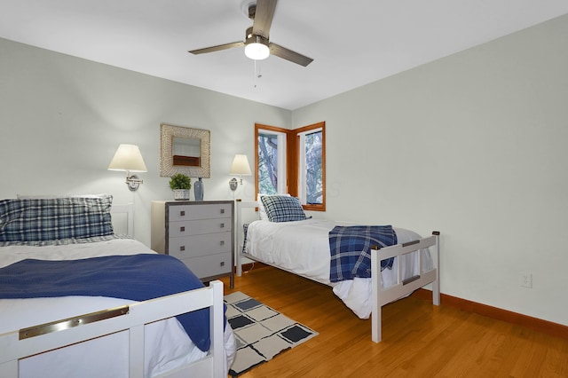 bedroom with ceiling fan, baseboards, and wood finished floors