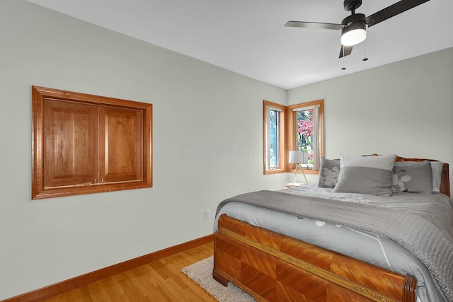 bedroom featuring baseboards, ceiling fan, and light wood-style floors