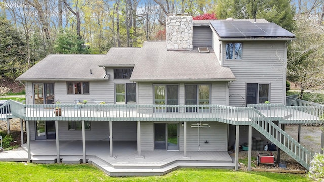 back of property featuring a shingled roof, a chimney, stairway, and a wooden deck