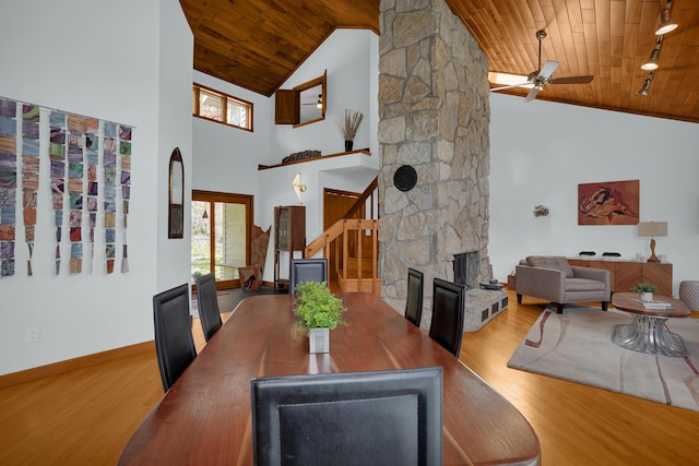 dining room featuring wood ceiling, a fireplace, baseboards, and wood finished floors