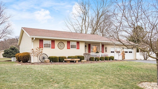 single story home with an attached garage, aphalt driveway, a front lawn, and a porch