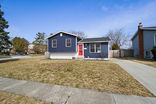 split level home with entry steps, a front lawn, and fence