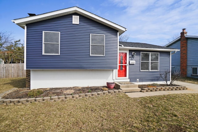 split level home with a front yard and fence