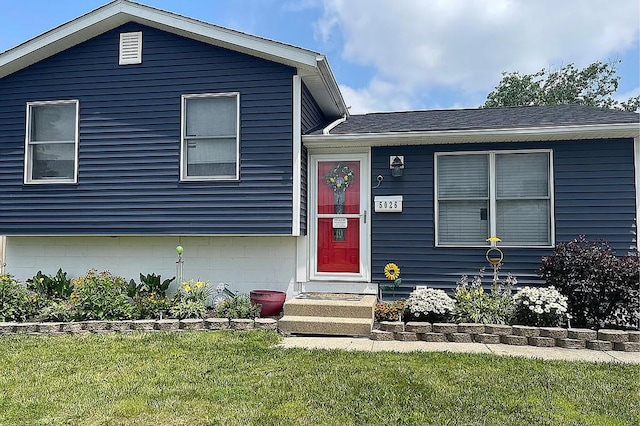 tri-level home with a front lawn