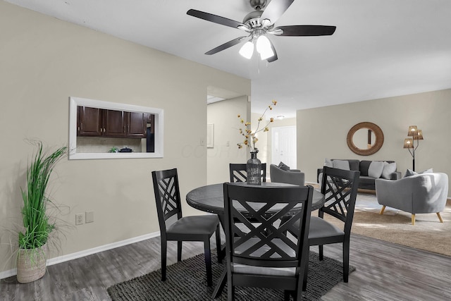 dining space featuring a ceiling fan, baseboards, and wood finished floors