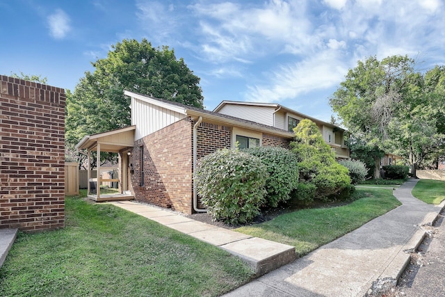 view of property exterior featuring brick siding and a lawn