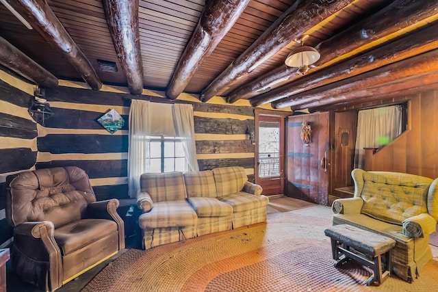 living room with visible vents, beam ceiling, wood walls, and wooden ceiling