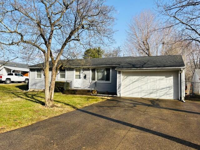 ranch-style home with a garage, aphalt driveway, and a front lawn