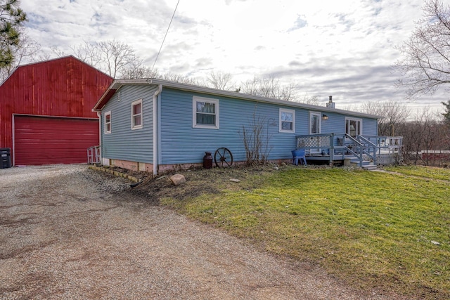 view of front of property with a front yard, a deck, a garage, driveway, and an outdoor structure