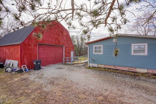 detached garage featuring gravel driveway and fence