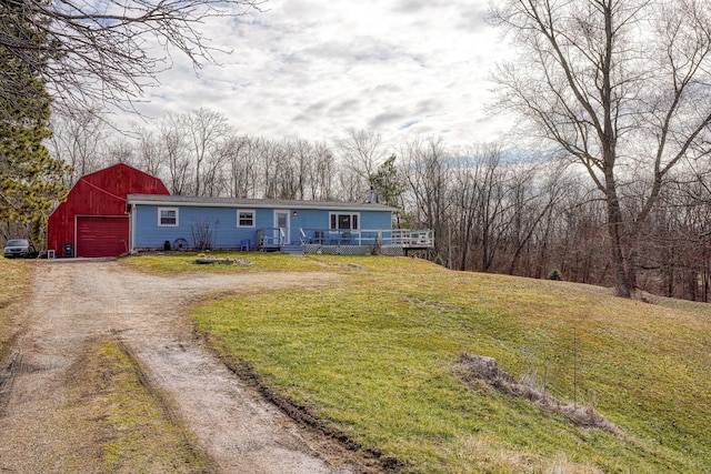 view of front facade with an outbuilding, a garage, a barn, driveway, and a front yard