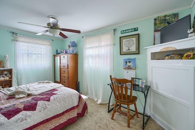 carpeted bedroom featuring ornamental molding and a ceiling fan