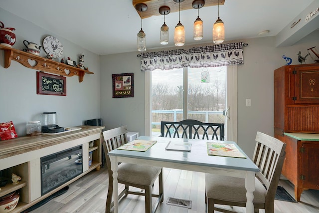 dining area featuring light wood-style floors and visible vents