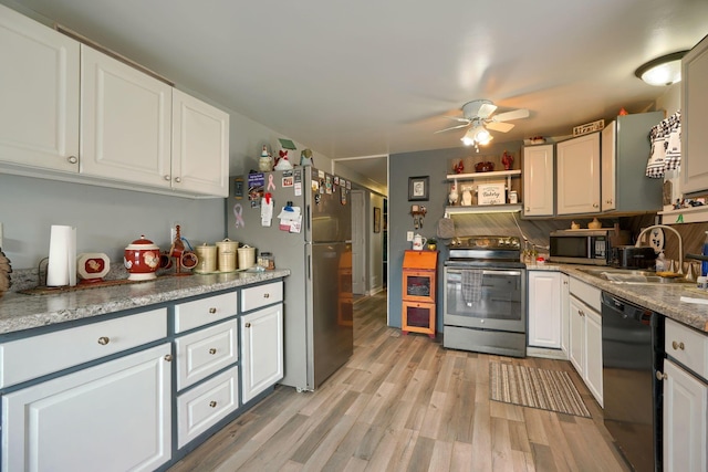 kitchen with ceiling fan, a sink, white cabinets, appliances with stainless steel finishes, and light wood finished floors