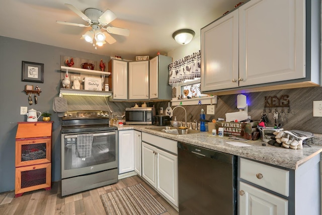 kitchen featuring a sink, stainless steel appliances, light wood-type flooring, white cabinetry, and backsplash