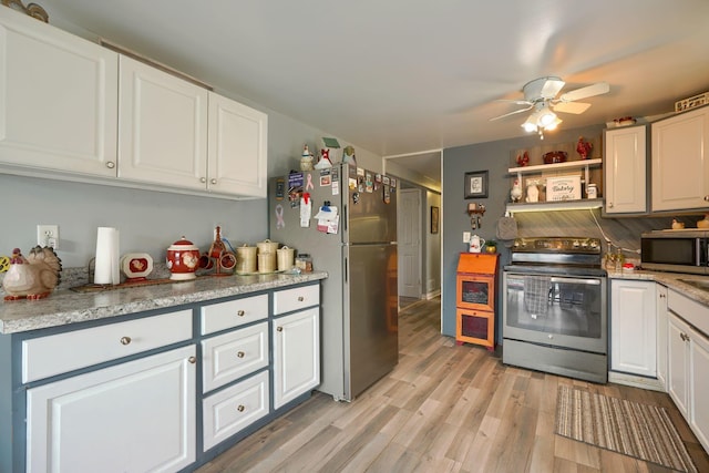 kitchen with white cabinets, ceiling fan, light wood-style flooring, and stainless steel appliances