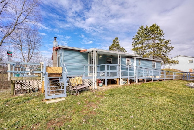 rear view of house with a chimney, a yard, and a deck