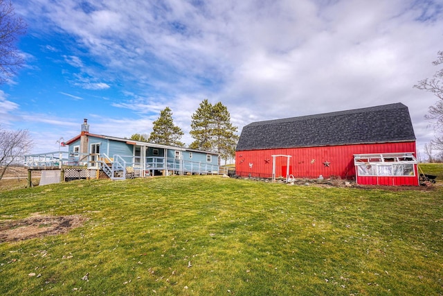 view of yard featuring an outbuilding, a deck, and a barn