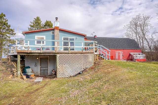 back of property with an outbuilding, a yard, and a wooden deck