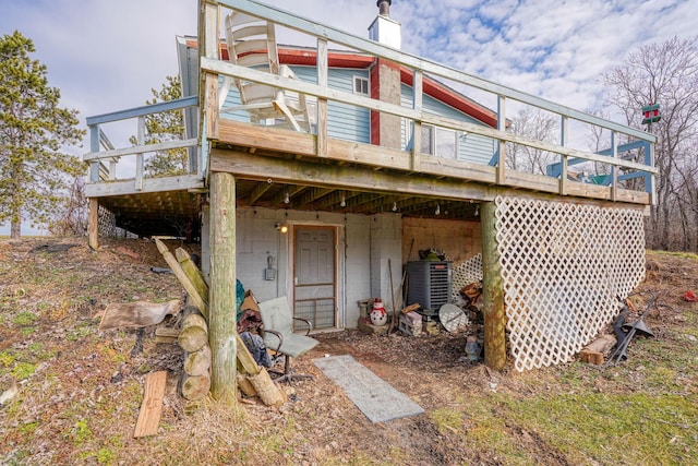 exterior space featuring a deck, central AC unit, and a chimney