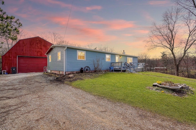 view of front facade featuring a garage, driveway, an outdoor structure, and a front yard