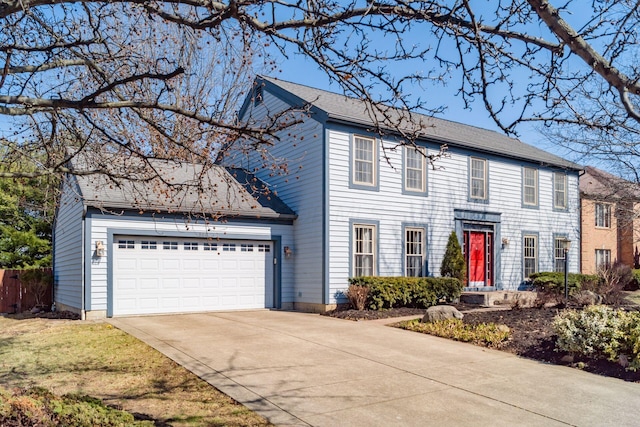 colonial house with concrete driveway and an attached garage