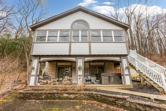 view of front facade featuring stone siding and stairway